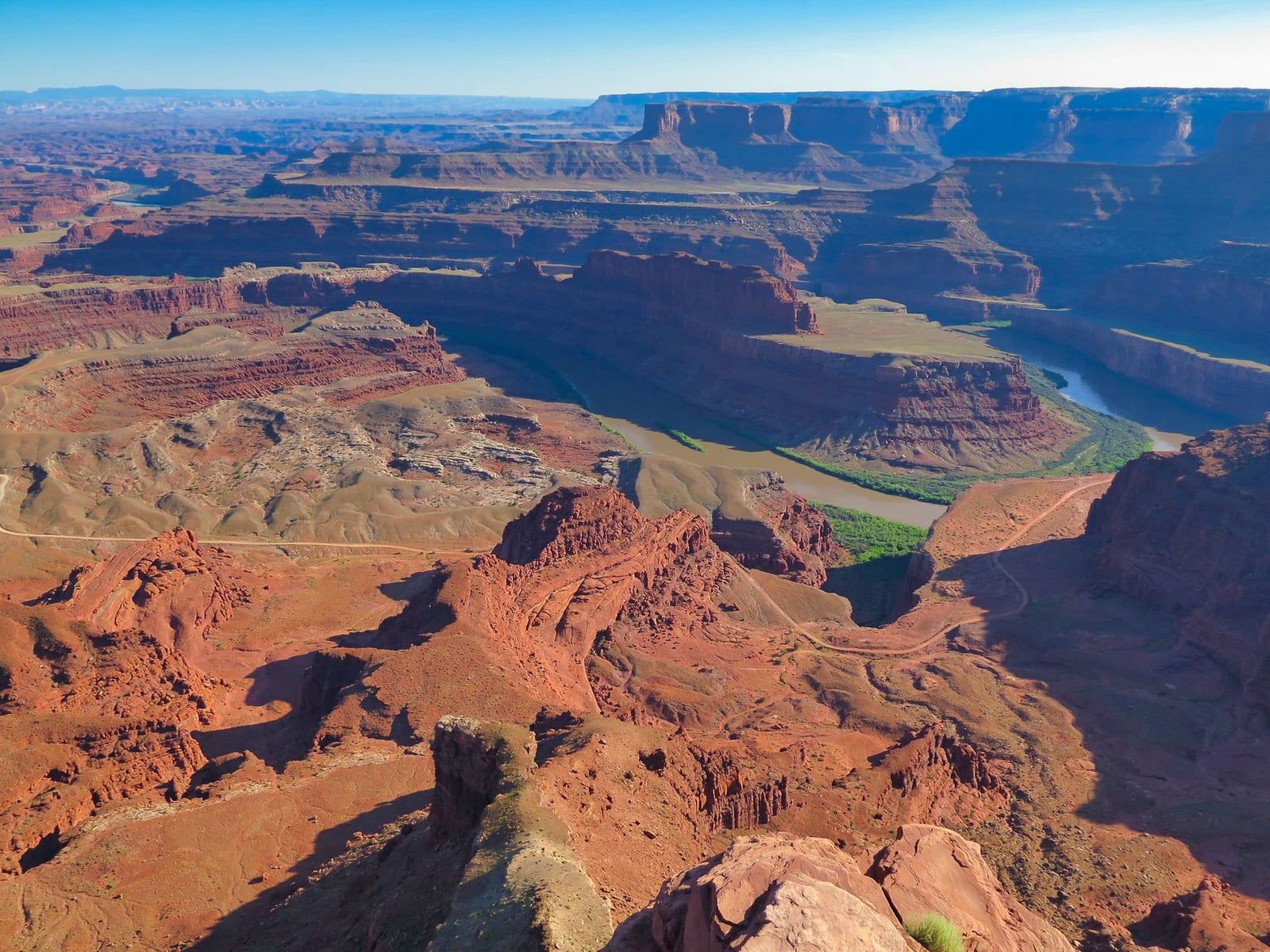 A scenic view over the winding Colorado River carving through layered red rock canyons at Dead Horse Point State Park near Canyonlands National Park.