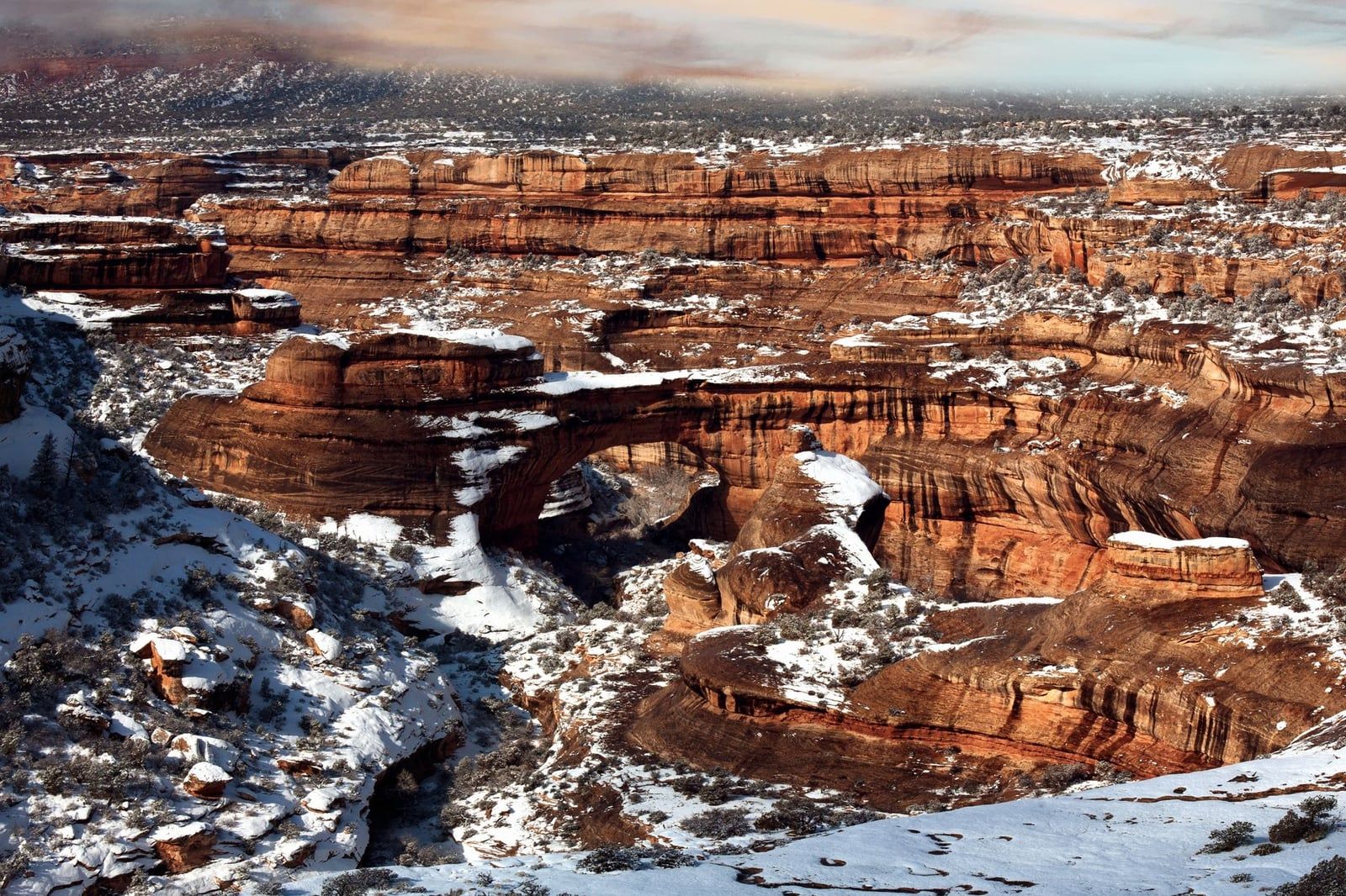 Snow dusts the red rock canyons and natural formations of Canyonlands National Park in winter.