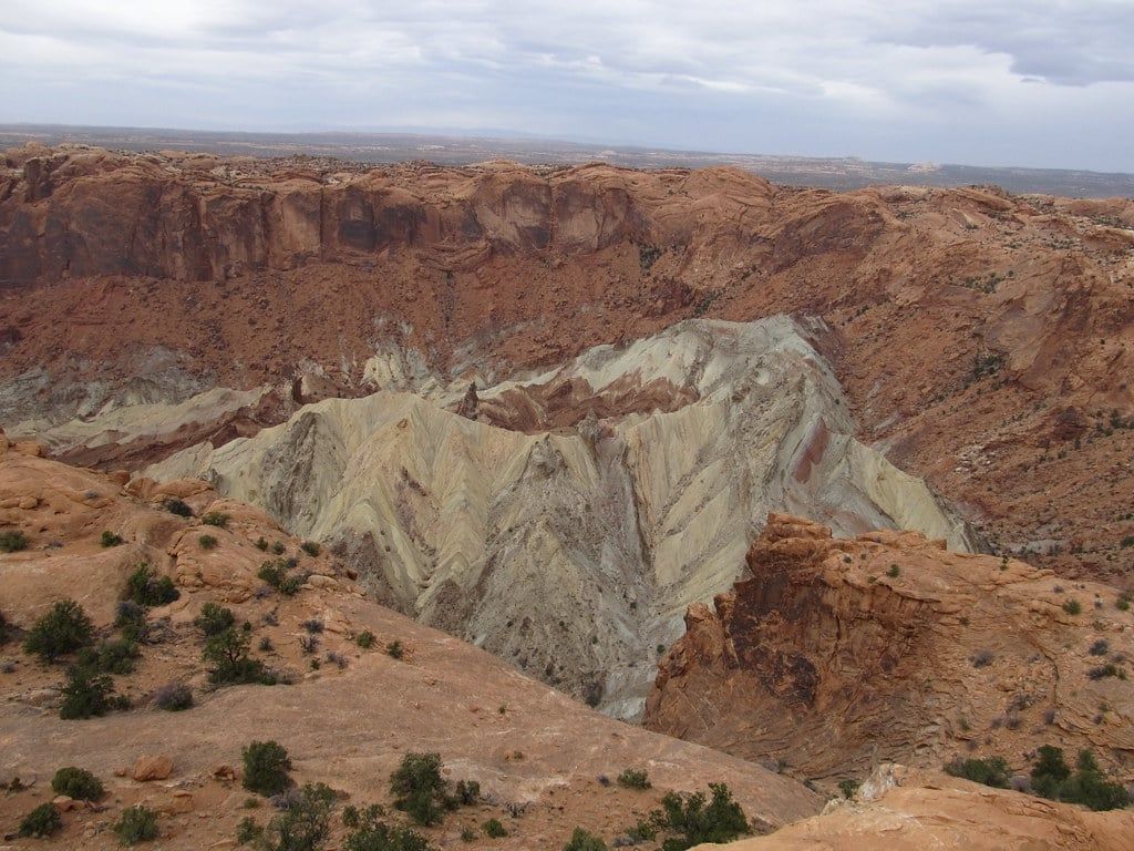 Una vista panoramica sull'enorme cratere di Upheaval Dome con la sua formazione rocciosa centrale chiara circondata da pareti di arenaria rossa nel Parco Nazionale di Canyonlands.