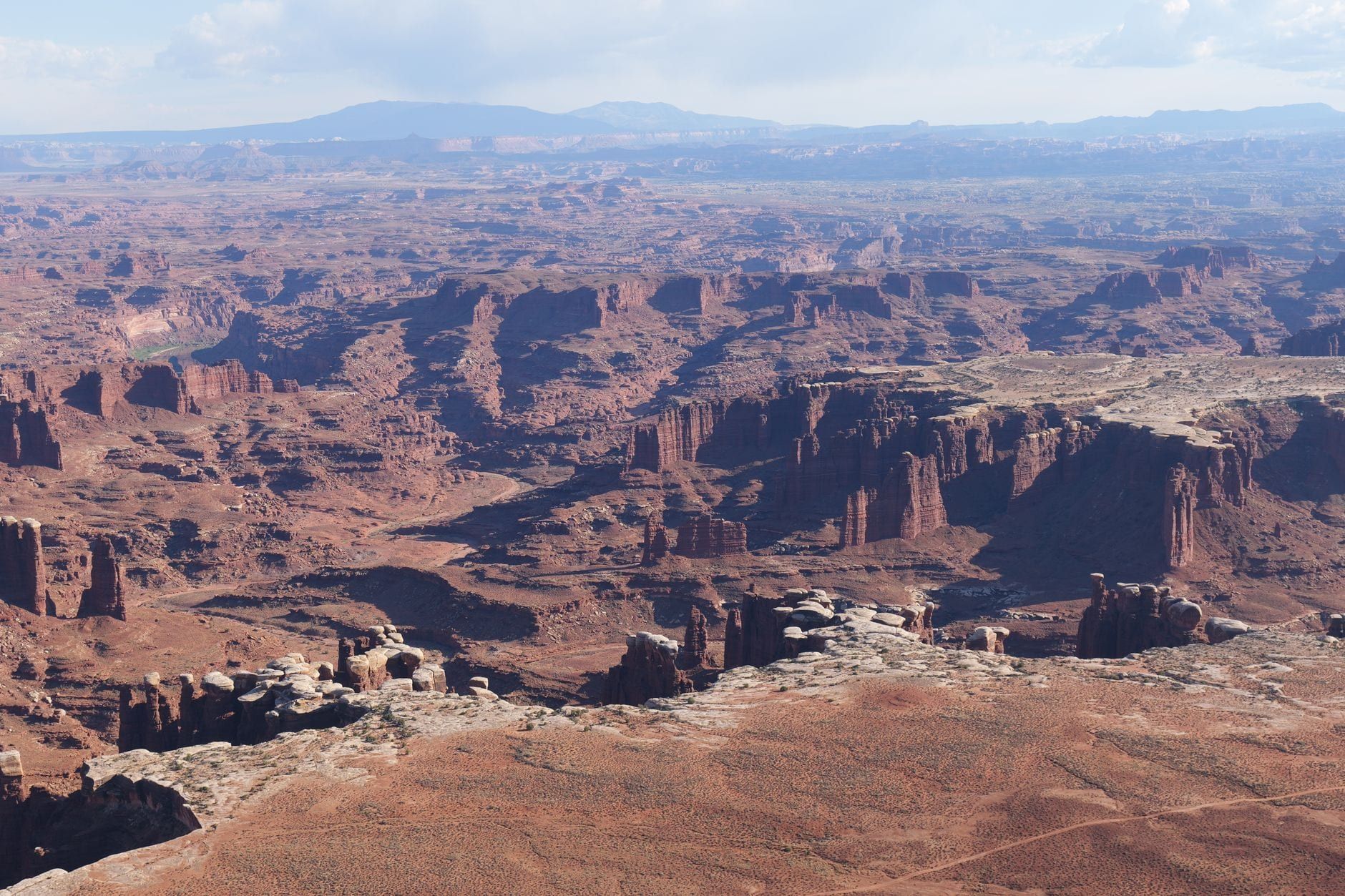 Weite Panoramaansicht über die zerklüfteten Canyons und Felsnadeln des Monument Basin im Canyonlands-Nationalpark.