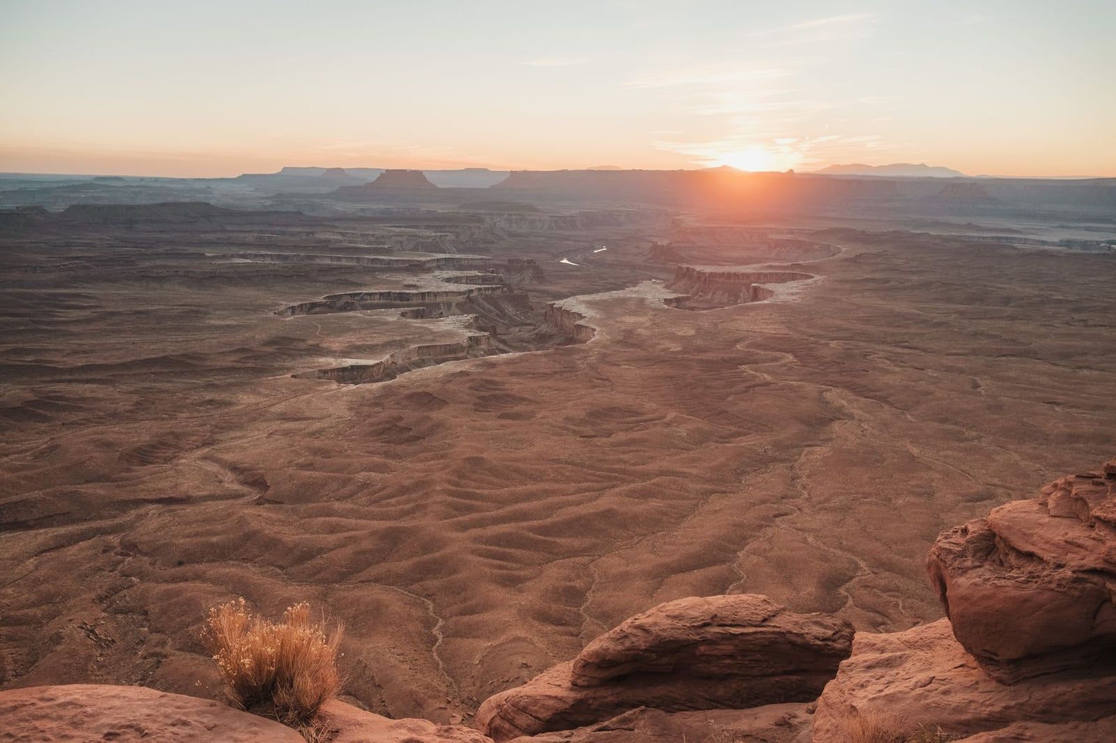 The low sun illuminates the rugged canyon country and White Rim sandstone below Grand View Point in Canyonlands National Park.