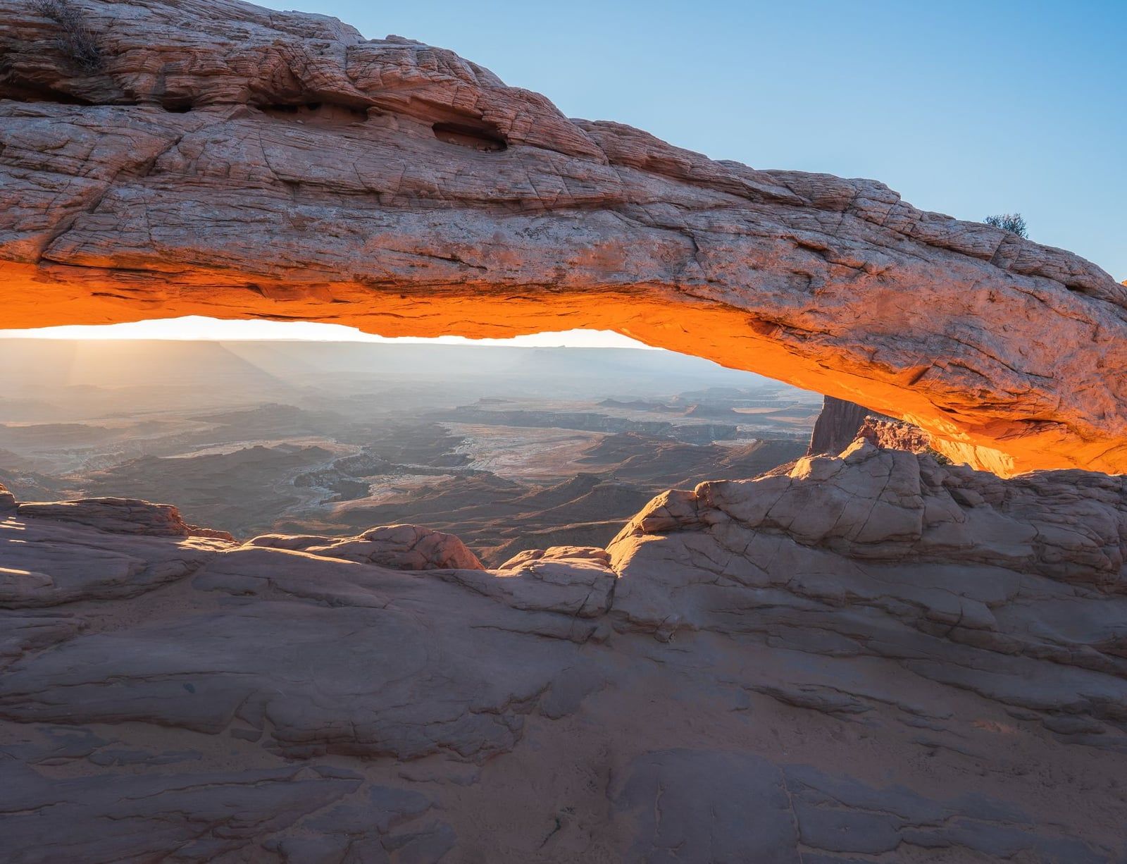 Mesa Arch illuminated with morning light framing the vast canyon landscape in Canyonlands National Park.