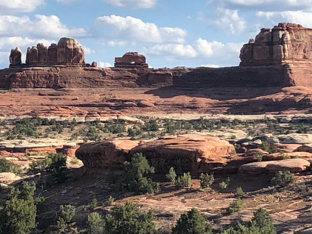 Wooden Shoe Arch perched atop a red rock formation in the Needles District of Canyonlands National Park.